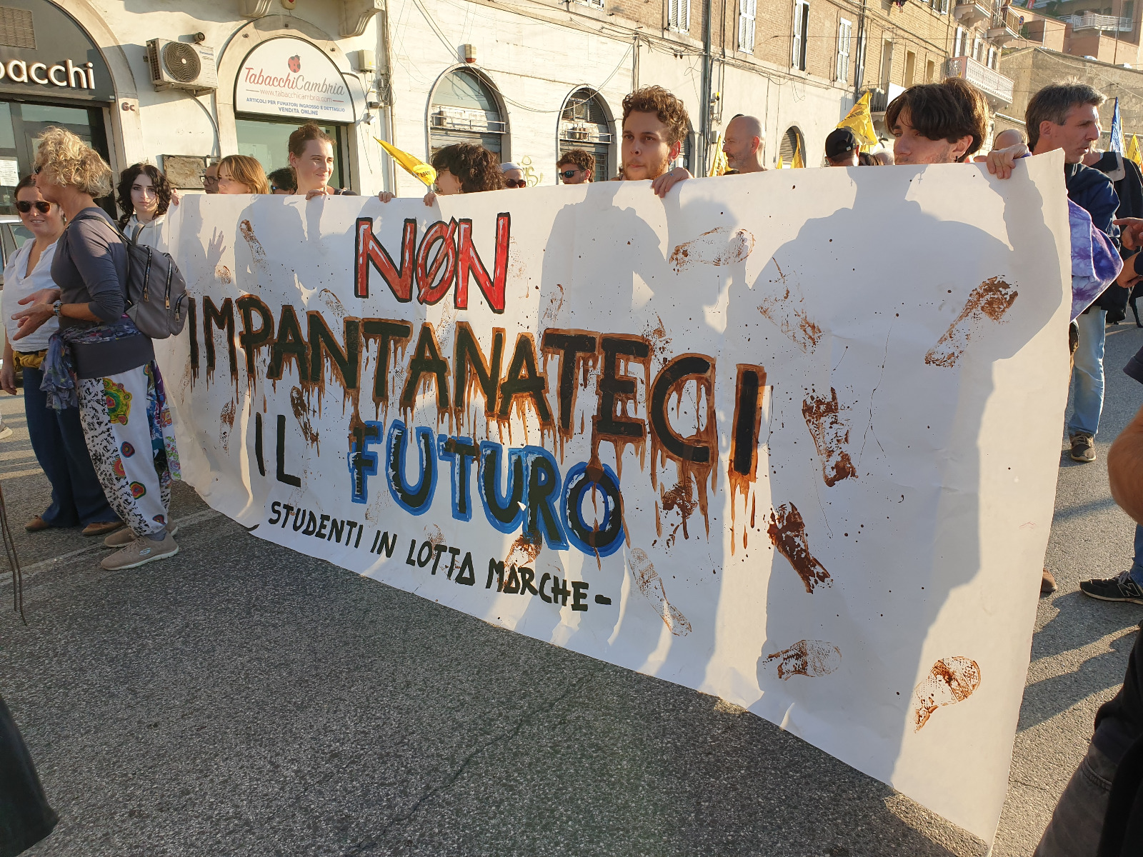 Lo striscione de Gli Studenti in lotta Marche recita "Non impantanateci il futuro"