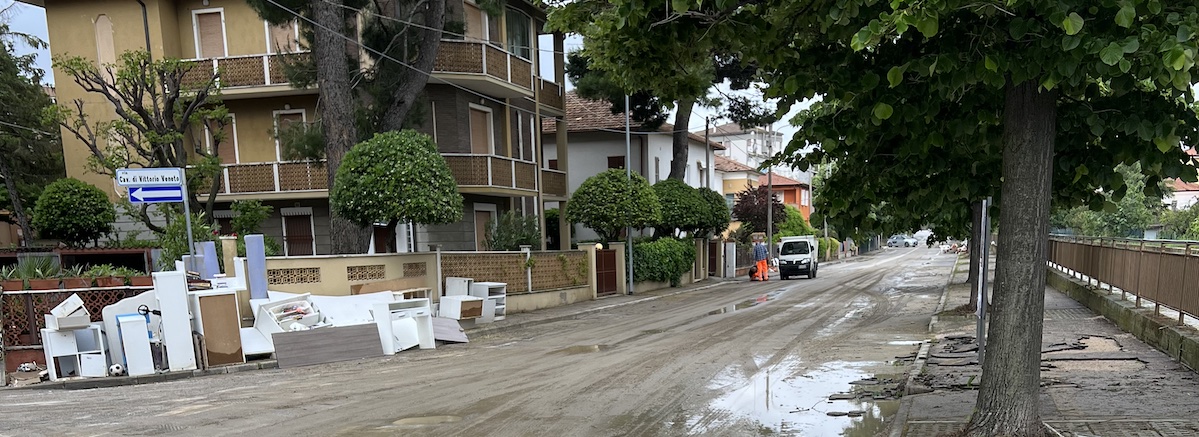 In Via Rovereto ci sono mobili ai bordi della strada, fango in carreggiata e marcipiede rotto